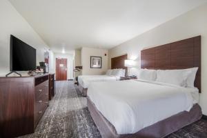 CozadCobblestone Hotel & Suites - Cozad的酒店客房设有两张床和一台平面电视。