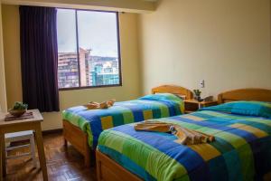拉巴斯Downtown Hotel的酒店客房设有两张床和窗户。