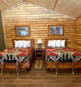 艾兰帕克Cabin Village的小木屋内一间卧室,配有两张床