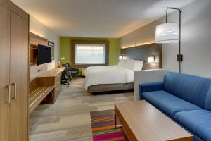 MonroeHoliday Inn Express - Cincinnati North - Monroe, an IHG Hotel的酒店客房,配有床和沙发