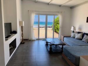 比亚米尔港Sandy Feet House的一间配备有床的客厅,享有海滩美景。