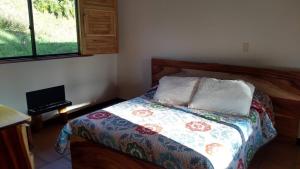 麦德林La Casona Del Retiro的一间卧室配有一张带被子和键盘的床