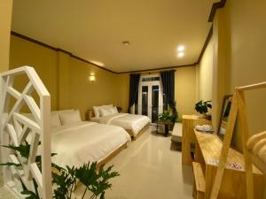 大叻CozyNook Boutique Apartments - 3 thang 2 Street的酒店客房设有两张床和一张桌子。