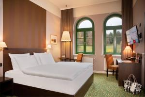 布兰肯堡Schlosshotel Blankenburg的卧室配有一张床、一张书桌和窗户。