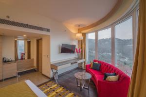 西姆拉The Zion Shimla的客厅配有红色沙发和钢琴