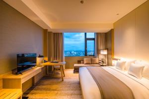 海防Hotel Nikko Hai Phong的酒店客房设有一张大床和一台电视。