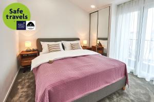 波德戈里察佩拉住宅Spa酒店的一间卧室配有一张带粉色和白色毯子的床