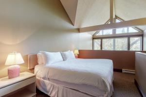 惠斯勒Greystone Lodge 314&315的卧室设有一张白色大床和一扇窗户。