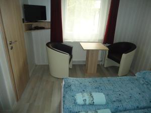 SzabadkígyósDeutsches Haus的小房间设有一张床、一张桌子和椅子