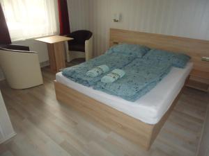 SzabadkígyósDeutsches Haus的一间卧室配有一张带蓝色棉被的床