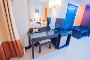廊开阿萨湾酒店的一间卧室配有一张桌子、一张床和一面镜子
