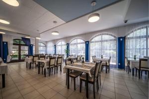 沃迪切Hotel Nikola的用餐室设有桌椅和窗户。