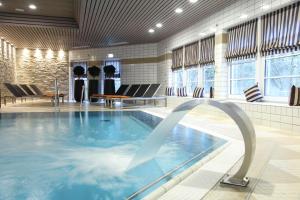 布劳恩拉格relexa hotel Harz-Wald Braunlage GmbH的一座带桌椅的游泳池