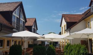 Hallerndorf瑞特码尔兰德伽斯豪夫酒店的庭院里一排带遮阳伞的建筑