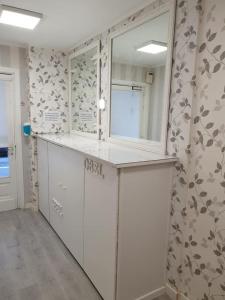 比利亚瓦Pension Obel的厨房配有白色橱柜和鲜花墙
