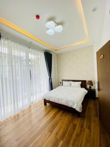 大叻Mỹ Lan hotel的一间卧室配有一张铺有木地板的白色床单。