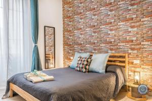 斯培西亚La Casa dei Treni Affittacamere city rooms for travel lovers的一间卧室设有砖墙和一张床