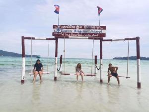 高龙撒冷岛甜蜜时光旅馆的三个女人坐在海滩的水中摆摆