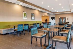 哈里斯堡Comfort Suites Camp Hill-Harrisburg West的餐厅内带桌椅的用餐室