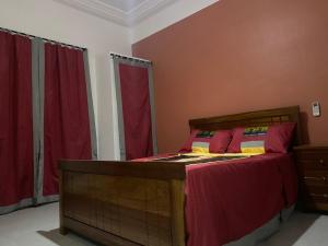 圣路易斯Gîte Le Toubé的一间卧室配有红色窗帘的床