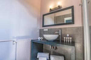 勒宝洛瑞莱斯查图士酒店的浴室设有水槽和墙上的镜子