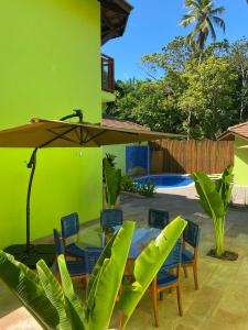 因巴塞The Madalena Pousada的庭院配有桌椅和遮阳伞。