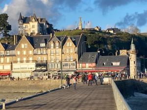 康卡勒STUDIO CANCALE - PORT DE LA HOULE - classé 2 étoiles的一群人走在码头上,在后面有城堡
