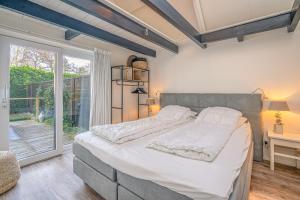 德科赫Zee van Tijd的一间卧室设有一张大床和一个窗户。