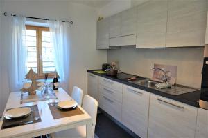 阿科Chalet Laghel的厨房配有白色橱柜、桌子和水槽。