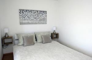 克尔克Apartmani Alta的卧室配有带两盏灯的白色床