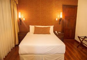 昆卡卡瓦洛酒店的卧室配有一张白色大床