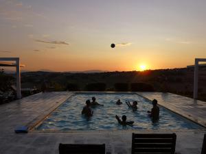 圣马赛罗泰努塔圣马赛罗酒店的一群人在日落时分在游泳池里