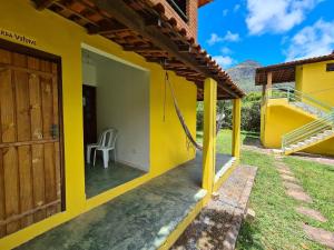 韦尔卡鲍Casa da Trilha的院子里的黄色房子,带椅子