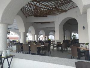 曼萨尼约Sierra Mar All Inclusive at Tesoro Manzanillo的大楼内带桌椅的餐厅