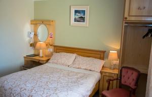 基拉尼阿尔格雷特食宿酒店的一间卧室配有一张床、一张书桌和一面镜子