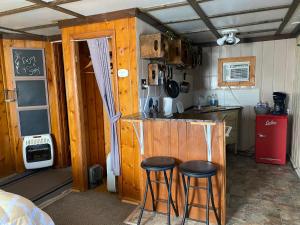 瑟莫波利斯Roundtop Mountain Vista - Cabins and Motel的一间小厨房,在一间房间里设有两个酒吧凳子