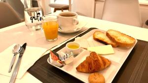 萨拉戈萨阿尔加河酒店的托盘,托盘里放着烤面包和面包,还有一杯咖啡