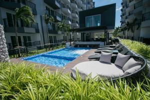 Ban Tha FatMantra Beach Condominium Suite - Mae Phim的一座酒店,毗邻一座建筑,设有游泳池和躺椅