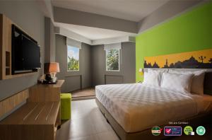日惹KHAS Malioboro Hotel的配有一张床和一台平面电视的酒店客房