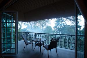 马迪凯里Coorg Wilderness Resort & Spa的美景阳台配有桌椅