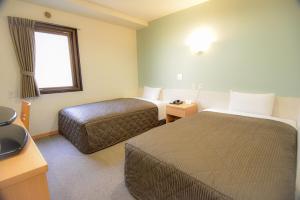 东京Kamata Inn Social的酒店客房设有两张床和窗户。