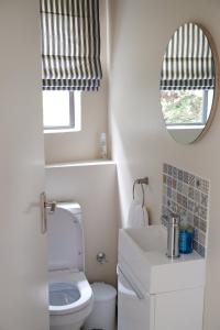 戈登湾By Die See的一间带卫生间、水槽和镜子的浴室