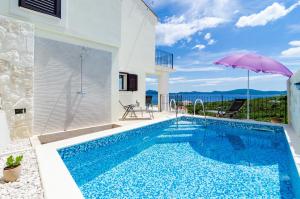斯拉诺Villa Sofija Dubrovnik & Peljesac Region的一座带游泳池和遮阳伞的别墅