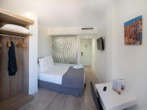 塞维利亚帕萨雷拉酒店的一间酒店客房,配有一张床和一台电视