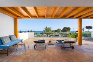 塞勒玛Romantik Villa的一个带蓝色沙发和桌子的庭院,享有海景