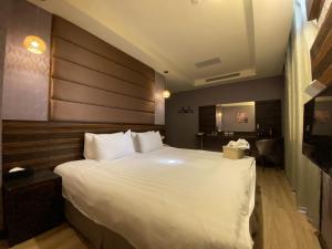 金城IN99精品旅馆的卧室配有一张白色大床和木制床头板