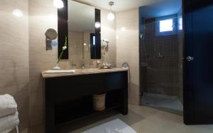 哈马马特新巴达旅馆的浴室配有盥洗盆和带镜子的淋浴