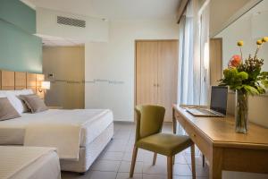 阿尔戈斯托利翁洛里安普莱萨酒店的酒店客房配有一张床和一张带电脑的书桌