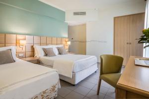 阿尔戈斯托利翁洛里安普莱萨酒店的酒店客房,配有两张床和椅子