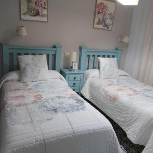 卡索拉Vivienda Rural Rio Cerezuelo的蓝色和白色的客房内的两张床